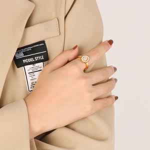 Detail view of a gold-plated teardrop gemstone ring with pavé rhinestones on finger