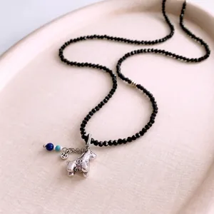 Minimalist long beaded necklace with silver horse pendant and faceted black beads