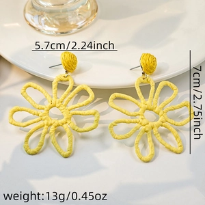 Macro shot of yellow raffia flower earrings showing size 5.7cm x 7cm and texture