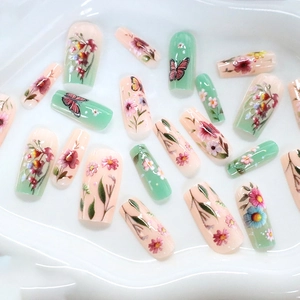 Floral and butterfly press-on nails in pastel pink and mint green glossy finish