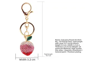Detailed view of peach keychain with pink rhinestones and zinc alloy gold plating