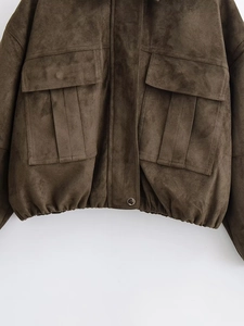 Detailed macro view of the olive brown suede texture and metal button on the utility jacket