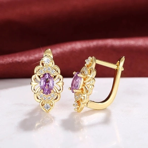 Hohl gestaltete goldene Ohrringe mit ovalem violettem Zirkon und Kristallen