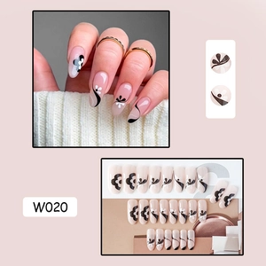 Close-up of W020 press-on nails set featuring nude base with black and white floral art