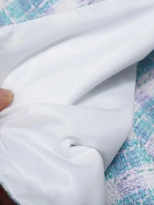 Close-up of the smooth white satin lining and blue tweed textured fabric of the suit