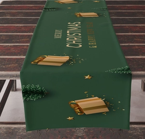 Detail of green linen Christmas table runner with Merry Christmas text on rustic wood