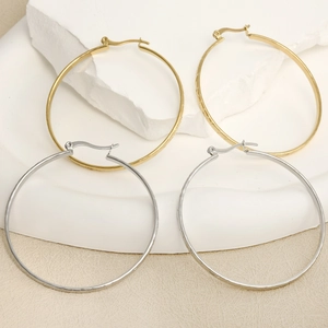Set of gold and silver U-shaped 304 stainless steel hoop earrings on a marble tray