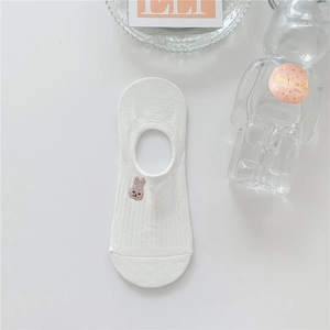 Close-up of white invisible boat sock with delicate rabbit embroidery and cotton texture