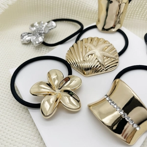 Detail showing five-piece metal hair ties set with floral and seashell patterns