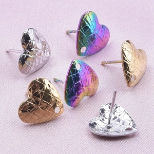 Macro shot of heart earrings with quilted pattern in gold, silver, and rainbow steel