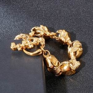 Close-up of golden titanium steel skull bracelet featuring a detailed toggle clasp design