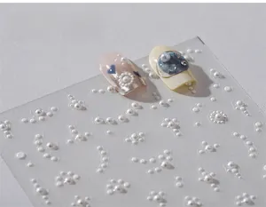 Macro shot of 3D pearl nail art stickers with various embossed patterns for manicures