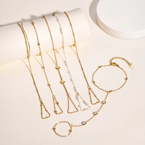 Elegant gold stainless steel hand chain bracelet with rings featuring pearls and zircon