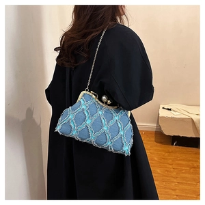 Blue denim shell bag with gold clasp and pearl detail shown on a model for scale