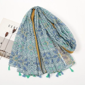 Detail of bohemian scarf with blue-green oval patterns and stylish fringed edges