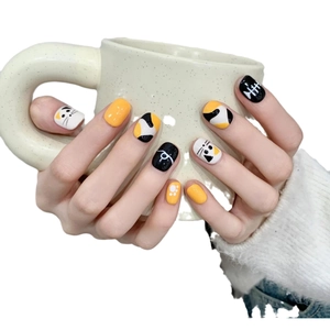 Handmade cat-themed press-on nails with fishbone patterns in yellow and black