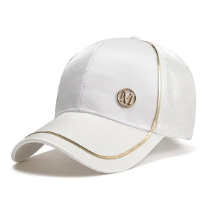 Detail shot of white satin baseball cap with gold piping and metallic M logo emblem