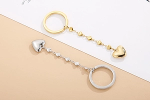 Detailed view of gold and silver stainless steel keychains with heart-shaped pendants