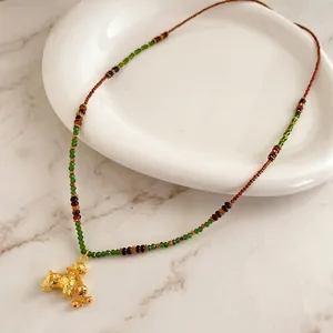 Vintage tiger eye beaded necklace with a golden poodle pendant and green crystal accents