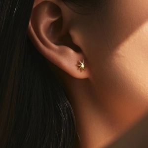 Elegance meets hip hop in these S925 silver gold star earrings on a model's ear