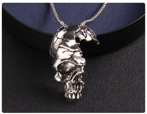 Vue macro d'un pendentif demi-crâne punk avec finition argentée vintage sur cuir noir