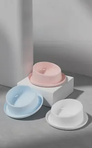 Detailed view of tilted ceramic cat bowls in pink, blue, and white with spill-proof tray