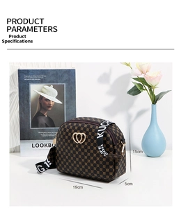Detail of vintage heart-shaped interlocking gold hardware on monogram crossbody bag