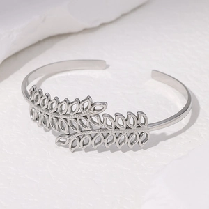 Brazalete abierto de acero inoxidable plateado con diseño elegante de hojas huecas minimalistas