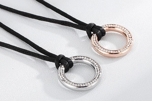 Detailed close-up of circular pendants in silver and rose gold with pavé set crystals