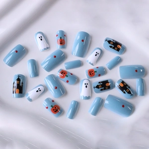 Halloween press-on nails with cute ghost, pumpkin, and castle designs on light blue base