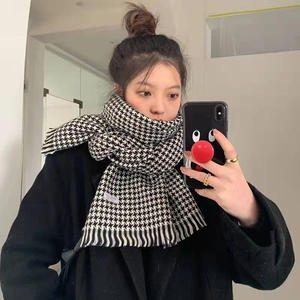 Minimalist black and white houndstooth knit scarf with tassels shown in a mirror selfie
