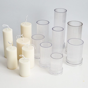 Detailed view of vertical striped cylinder candle molds and white pillar wax creations