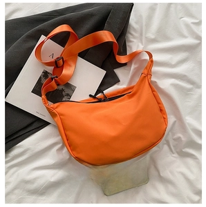 Top view of orange nylon dumpling bag showing adjustable wide strap and dual zipper closure