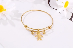 Détail du bracelet en acier titane doré avec pendentif garçon et perles sur marguerites