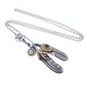 Macro detail of titanium steel necklace with eagle claw and feather charms