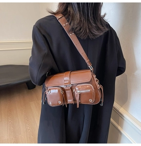 Detail view of a vintage brown crossbody bag with double zip pockets and silver hardware