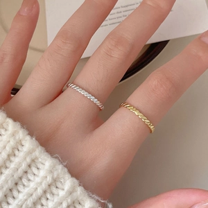 Detailed view of woven S925 sterling silver rings in gold and silver twist texture