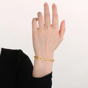 Close-up of a stylish gold square wire chain bracelet worn on a wrist with minimalist design