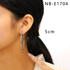 Detailed view of 5cm oversized stainless steel hoop earrings worn by a model