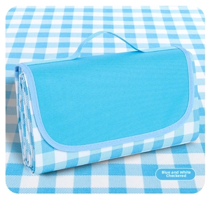 Close-up of portable blue and white checkered Oxford cloth picnic mat with carry handle