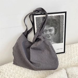 Detail view of the deep gray pleated canvas bag with adjustable metal buckle strap