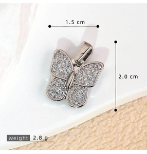 Macro shot of butterfly pendant with pavé zircon stones measuring 1.5 cm by 2.0 cm