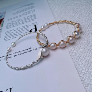 Detail of handmade 14K plated wire-wrapped bracelets with lustrous freshwater pearls