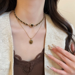 Dettaglio della collana a doppio strato in oro 18k con pendenti in pietra occhio di tigre