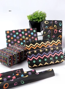 Detail of matte black wrapping paper with colorful geometric patterns and gift boxes