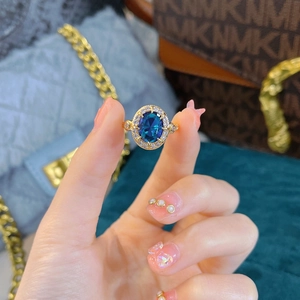 Luxury royal blue sapphire oval ring with gold band and sparkling diamond accents