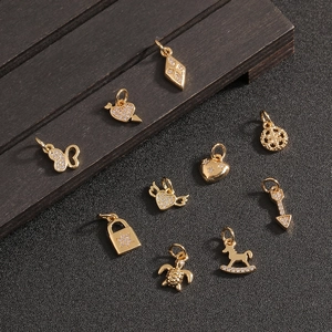 Pendentifs tortue et cœur dorés avec cristaux sur fond de bois sombre