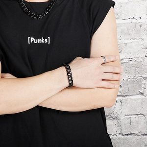 Close-up of black Cuban link bracelet and necklace set on model with punk style