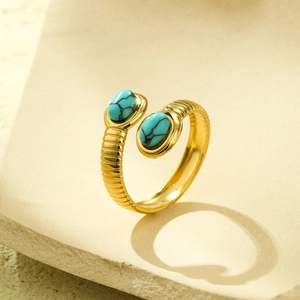 Detail of adjustable gold ring featuring oval turquoise stones and textured metal band