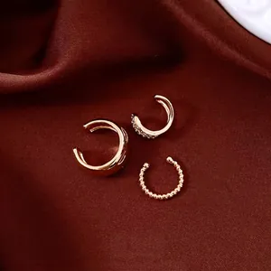 Elegant set of three 18k gold-plated zircon ear cuffs displayed on a luxury silk backdrop